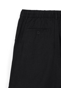 Schwarze leichte Hose mit elastischem Bund, ausgestattet mit einer einzelnen Gesäßtasche mit Knopf und einer glatten Textur.