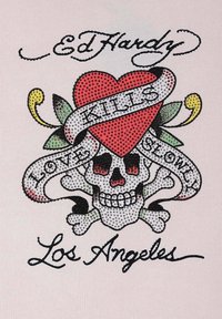 Bílá látka s barevným designem lebky zdobenou kamínky, červeným srdcem, květinovými akcenty a textem: "Zabíjí lásku pomalu."