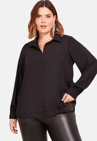 Camicia nera con bottoni, maniche lunghe, colletto e vestibilità comoda, realizzata in un tessuto liscio con dettagli minimi.