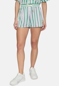 Pantaloni corti a righe verdi e bianche con dettagli viola, dotati di una vita con cordino e tasche laterali, abbinati a sneakers bianche.
