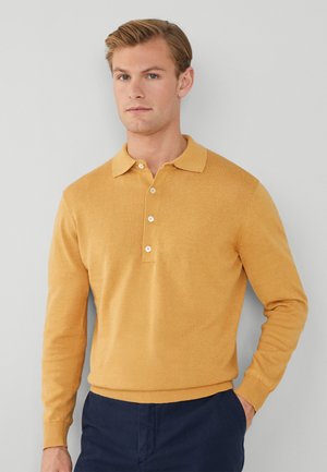 Maglione polo a maniche lunghe di colore giallo senape realizzato in tessuto morbido, dotato di colletto e patta con tre bottoni. Polsini e orlo a costine.