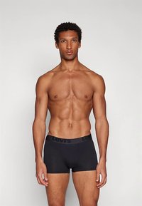 Cuecas boxer de algodão preto com elástico largo na cintura apresentando o logótipo "Levi's", design ajustado e textura suave.