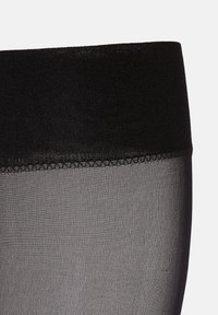Collant neri trasparenti con una fascia in vita nera testurizzata. Il materiale è liscio e semitrasparente, con un design senza cuciture.