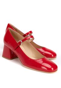 Talons en cuir verni rouge avec un bout rond, un talon bloc de hauteur intermédiaire et une double sangle ajustable sur le cou-de-pied.