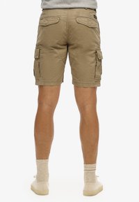 Shorts cargo kaki à coupe décontractée, dotés de plusieurs poches, de coutures décoratives et d'un tissu légèrement texturé.