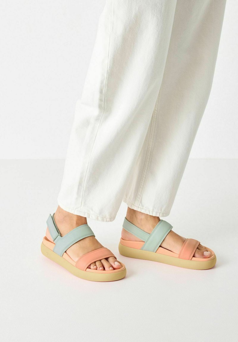 Two-tone sandals featuring a soft pink and mint green color scheme, made with a smooth material and a cushioned rubber sole.