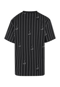 Schwarzes kurzärmeliges T-Shirt mit dünnen weißen vertikalen Streifen und verstreuten kleinen weißen abstrakten Linienzeichnungen auf der Rückseite.