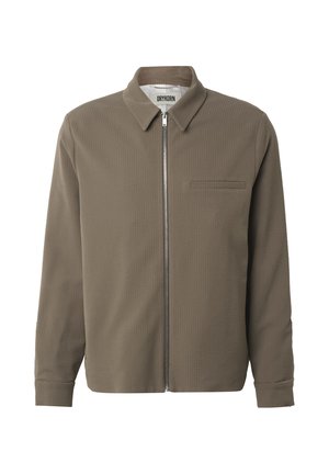 Męska brązowa teksturowana kurtka zapinana na zamek z kołnierzem i pojedynczą kieszenią na piersi, z widoczną metką marki wewnątrz kołnierza.