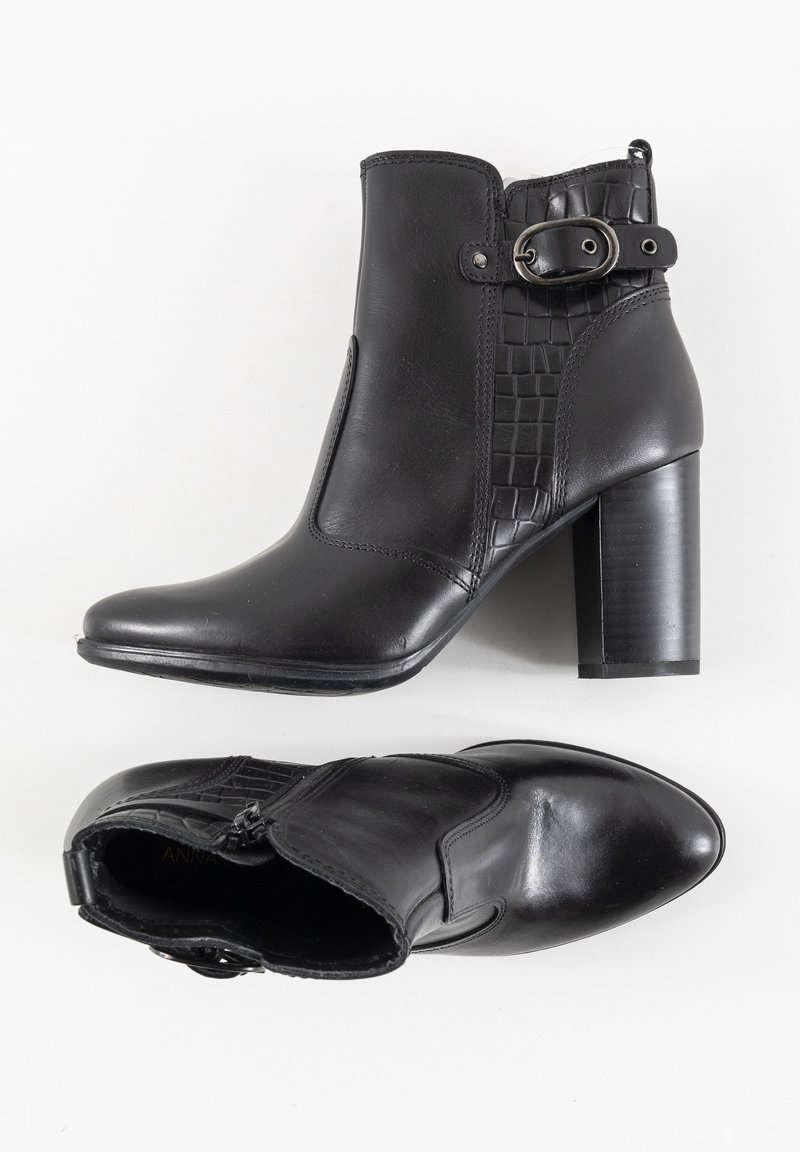 Bottines en cuir noir avec talons blocs, fermeture éclair latérale, sangles à boucle et panneau texturé sur le côté extérieur.