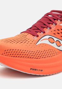 Oranje hardloopschoen met een bovenwerk van mesh, bordeauxrode veters, iconische branding op de zijkant en PWRRUN+ demping. Lichtgewicht en ademend ontwerp.