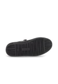 Zwarte schoenzool met een gestructureerd grippatroon. De zool heeft richels en een centraal logo. Stevig rubbermateriaal is zichtbaar.