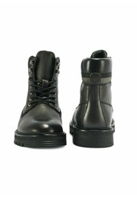 Czarne skórzane botki za kostkę z teksturowanym wykończeniem, okrągłym noskiem, sznurowanym zapięciem oraz grubą gumową podeszwą, z paskowanym akcentem na pięcie.