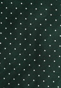 Musta vihreä kangas, jossa on teksturoitu kudonta ja säännöllinen kuvio pienistä, tasaisesti sijoitetuista valkoisista pilkuista.