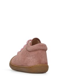 Zapato de ante rosa con punta redondeada y suela de goma. Presenta cordones rosas y un acento de costura. Logo visible en el talón exterior.