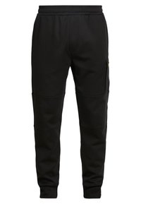 Pantalones de chándal negros fabricados con tela gruesa, con cintura elástica, bolsillos laterales y parches en las rodillas para mayor durabilidad.