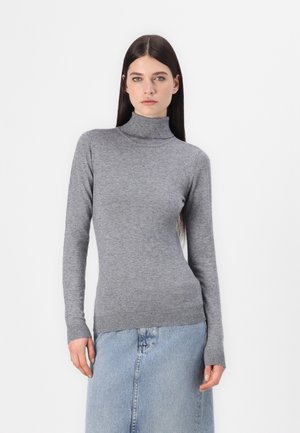 Pull col roulé gris en tricot doux, avec des manches longues et des poignets et un ourlet côtelés, associé à une jupe en denim bleu clair.