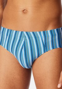 Heren zwemslips in blauw, groen en witte verticale strepen. Gemaakt van gladde stof met een snug fit en een comfortabele tailleband.