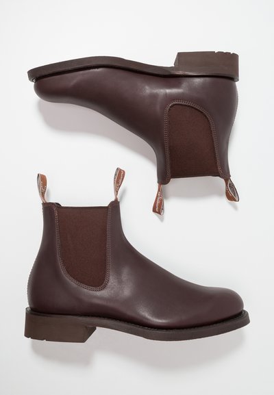 Bottes chevilles en cuir marron avec panneaux élastiques sur les côtés ; bout rond et petit talon ; languettes en cuir avec étiquette de marque à l'arrière.