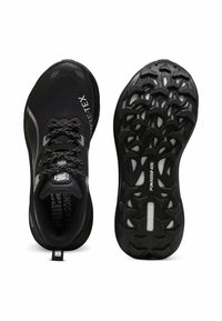 Czarne buty do biegania z cholewką Gore-Tex, teksturowanym wzorem, zaokrąglonym noskiem oraz wytrzymałą gumową podeszwą z wzorem zapewniającym przyczepność.