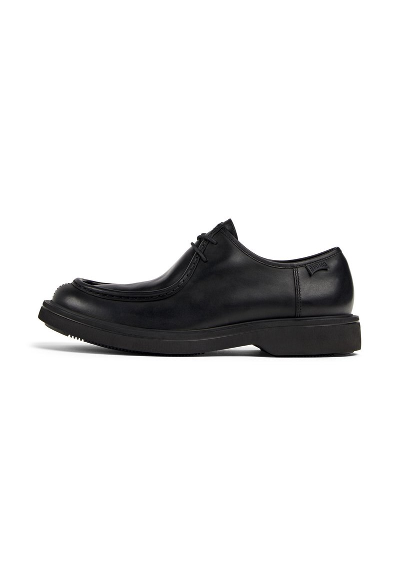 Black leather lace-up dress shoe with thick sole and rounded toe, viewed from the side on a white background.