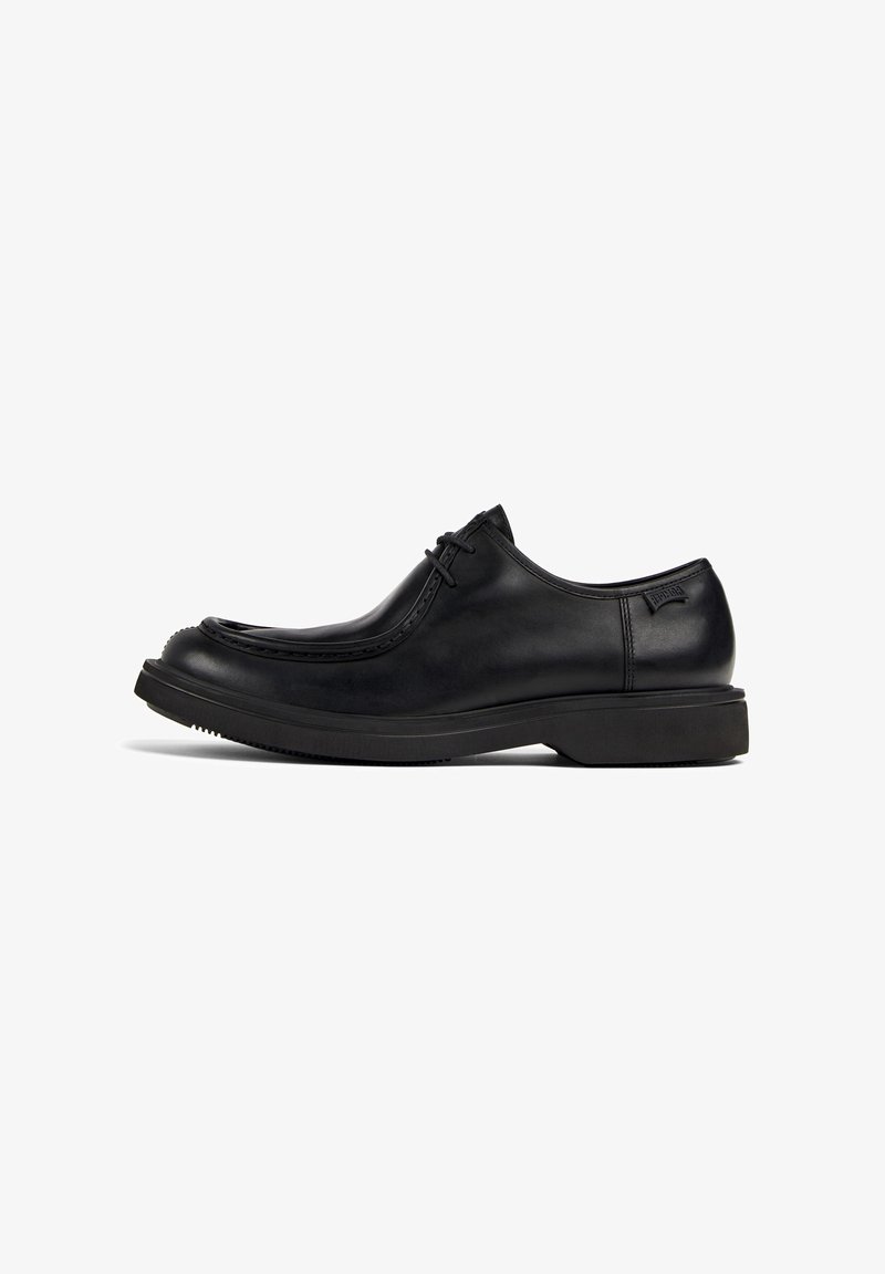 Black leather lace-up dress shoe with thick sole and rounded toe, viewed from the side on a white background.