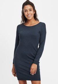 Tume navy sinine sviiterkleit pikkade varrukatega, laia kaelusega ja nööridega äärtes. Valmistatud pehmest kudumaterjalist, millel on sile tekstuur.