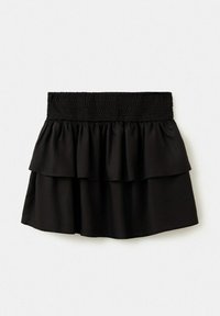 Mini-jupe noire superposée avec taille élastique smockée et tissu doux et fluide, présentée à plat sur fond blanc.