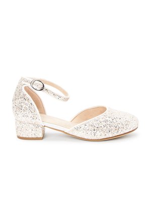Chaussure blanche scintillante à petit talon, bout fermé et bride à la cheville, dotée d'une boucle ronde argentée et d'une doublure intérieure beige lisse.