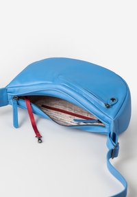 Blaue Leder-Umhängetasche mit einem Reißverschlussfach, roten Reißverschlussdetails, glatter Textur und verstellbarem Trageriemen. Das Innere zeigt ein beiges Futter.