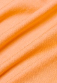 Orange fabric with a smooth texture and fine ribbing, draped in soft folds, emphasizing its lightweight and flexible nature.