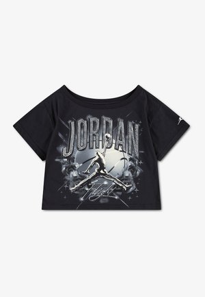 Μαύρο crop top με "JORDAN" με μεγάλα γράμματα, ασημί λογότυπο Jumpman σε κάρφωμα και επιγραφή "Flight" μπροστά, μικρό λογότυπο στο μανίκι.