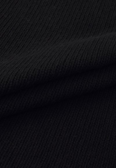 Tissu noir côtelé affichant une texture douce et un motif uniforme de lignes verticales, légèrement replié pour révéler de la profondeur et des couches.