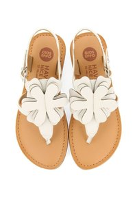 Sandalias blancas con un gran diseño floral en la tira de los dedos, correa ajustable en el tobillo y plantilla de cuero sintético color tostado. Detalles de costura en los bordes.