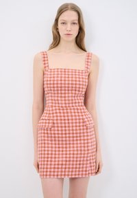 Abito aderente con scollatura quadrata, motivo a quadri rosa e arancio, e dettagli peplum in vita. Realizzato in tessuto strutturato.