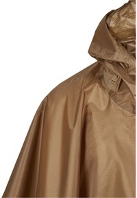 Beige regnponcho med hætte. Fremstillet af letvægts, vandafvisende materiale med et subtilt firkantet mønster og en glat tekstur.