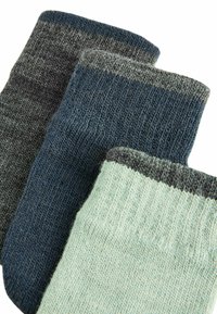 Tres pares de calcetines: gris oscuro, azul marino y verde menta claro; textura acanalada con puños en tonos más claros.