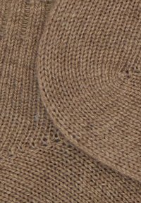 Tessuto a maglia marrone con una texture liscia, caratterizzato da un design a coste e circolare. Il colore è uniforme con leggere variazioni.