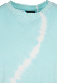 Světle modré bavlněné tričko s kulatým výstřihem, které se vyznačuje bílým tie-dye vzorem vytvářejícím vlnkový efekt na látce.