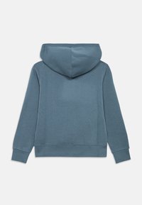 Μπλούζα με κουκούλα από μαλακό, υφασμάτινο μπλε υλικό. Διαθέτει μακριά μανίκια, ribbed μανσέτες και καγκουρό τσέπη. Λείο φινίρισμα, μινιμαλιστικός σχεδιασμός.