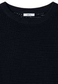 Pull en maille texturée bleu marine avec col rond côtelé et étiquette blanche de la marque indiquant "CECIL" au niveau du col.