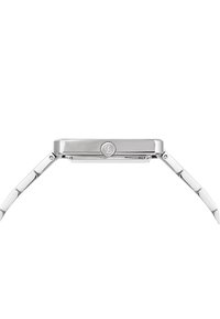 Λεπτό ορθογώνιο ασημί ρολόι χειρός, απεικονιζόμενο πλάγια, με μπρασελέ από γυαλισμένο μεταλλικό σύνδεσμο και μικρό κορώνα με χαραγμένο λογότυπο.