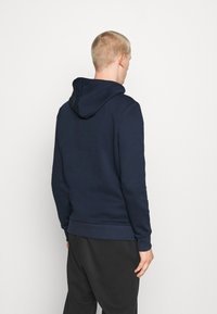 Felpa blu navy con cappuccio regolabile, polsini e orlo a costine, texture morbida e vestibilità comoda, mostrata dal retro.