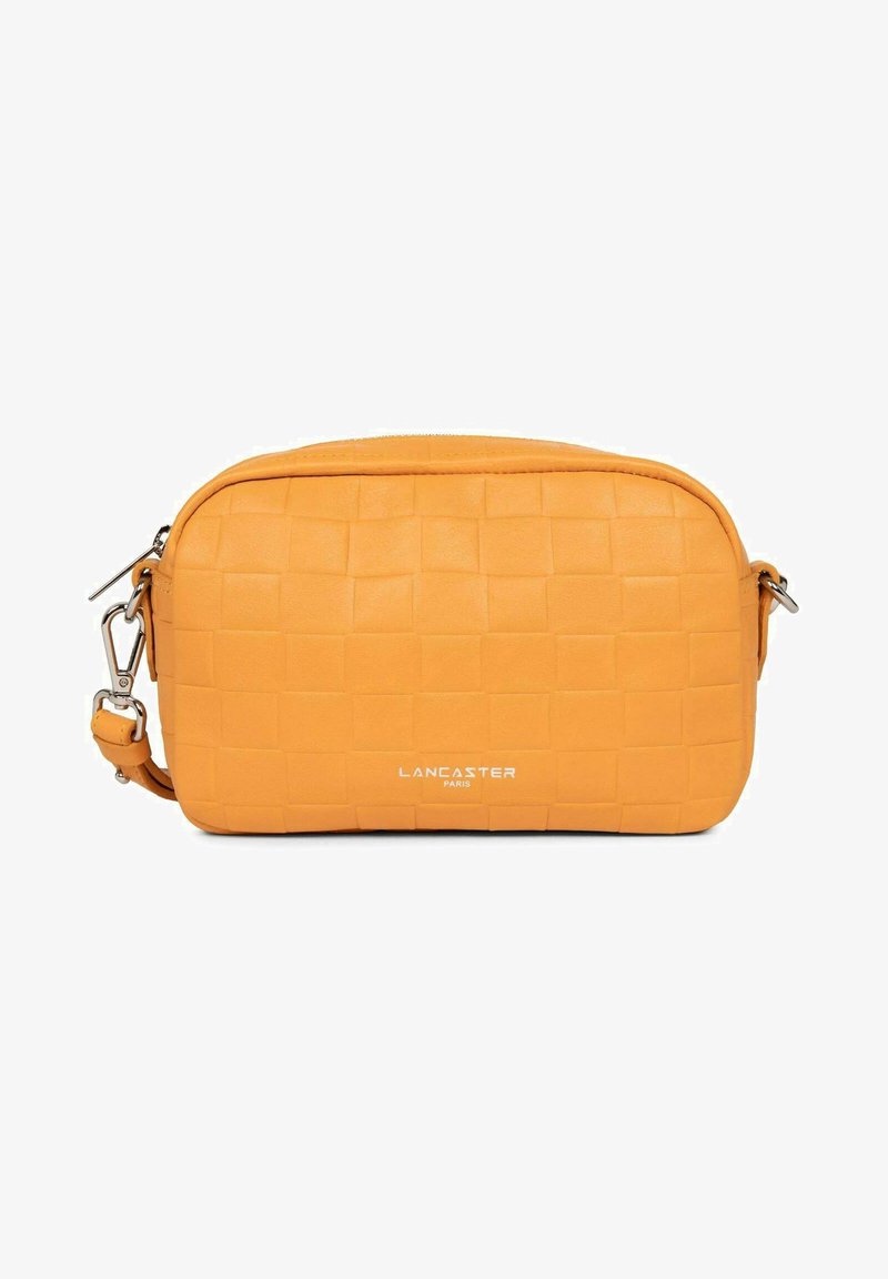 Un sac bandoulière en cuir synthétique orange présente une texture tissée, une fermeture éclair et des accessoires en argent. Le logo "Lancaster Paris" est affiché à l'avant.