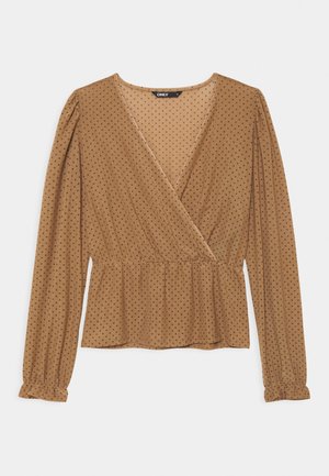 Blouse marron clair à manches longues avec petits pois sombres, col en V avec devant croisé, taille froncée et poignets à volants.