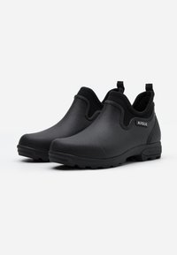 Black rubber ankle boots with textured finish, elastic side panels, and pull tabs. Features a rugged sole for improved traction.