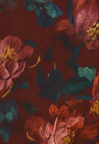 Tessuto a motivo floreale in rosso intenso con grandi fiori rosa e gialli, foglie verdi e pennellate testurizzate che creano un design vivace.