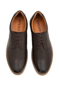 Tummanruskeat nahkakengät, joissa on teksturoitu pinta, pyöreä kärki, ruskeat nauhat ja vaaleanruskea kumipohja. Sisäpuolella on pehmustettu vaaleanruskea pohjallinen.