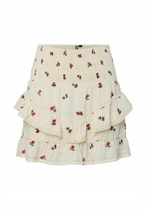 Gonna bianca a volant con vita arricciata e motivi di ciliegie rosse. Il tessuto presenta un design texturizzato a pois e dettagli in pizzo.