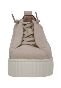 Beige Wildlederschuh mit runder Spitze, vorderem Schnürdesign und dicker, weißer Gummisohle mit geriffelter Textur. Zwei Ziehlaschen an der Zunge.