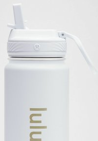 Valkoinen ruostumattomasta teräksestä valmistettu vesipullo, jossa on karhea, matta pinta, käännettävä kansi ja kultainen logo; korkea, sylinterimäinen muoto.